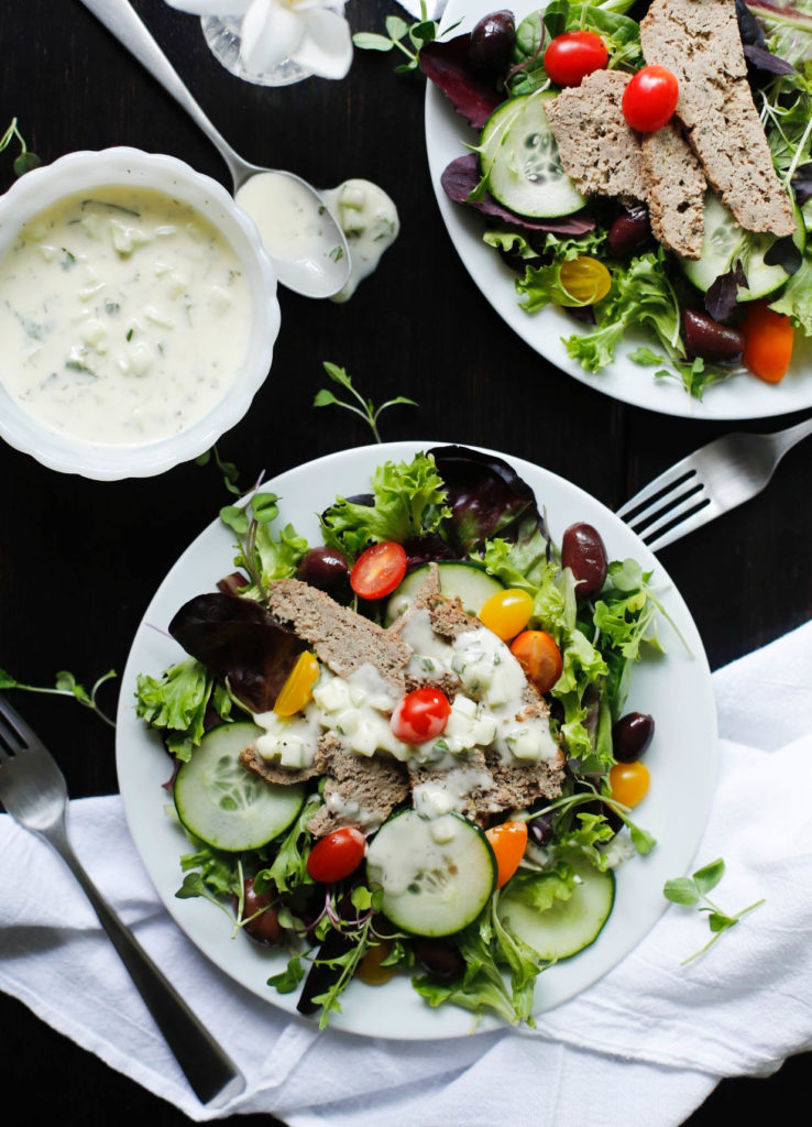 Lamb gyro meat on salad with vegetables and tzatziki sauce
