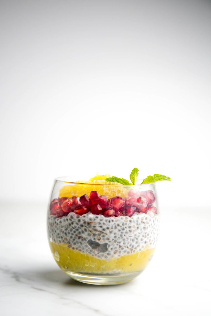 Chia seed pudding with pomegranate seeds and oranges with mint