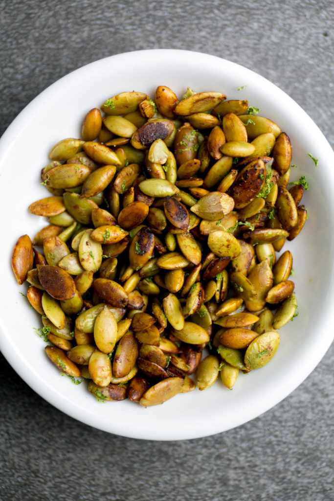 Lime roasted pumpkin seeds in a small white dish
