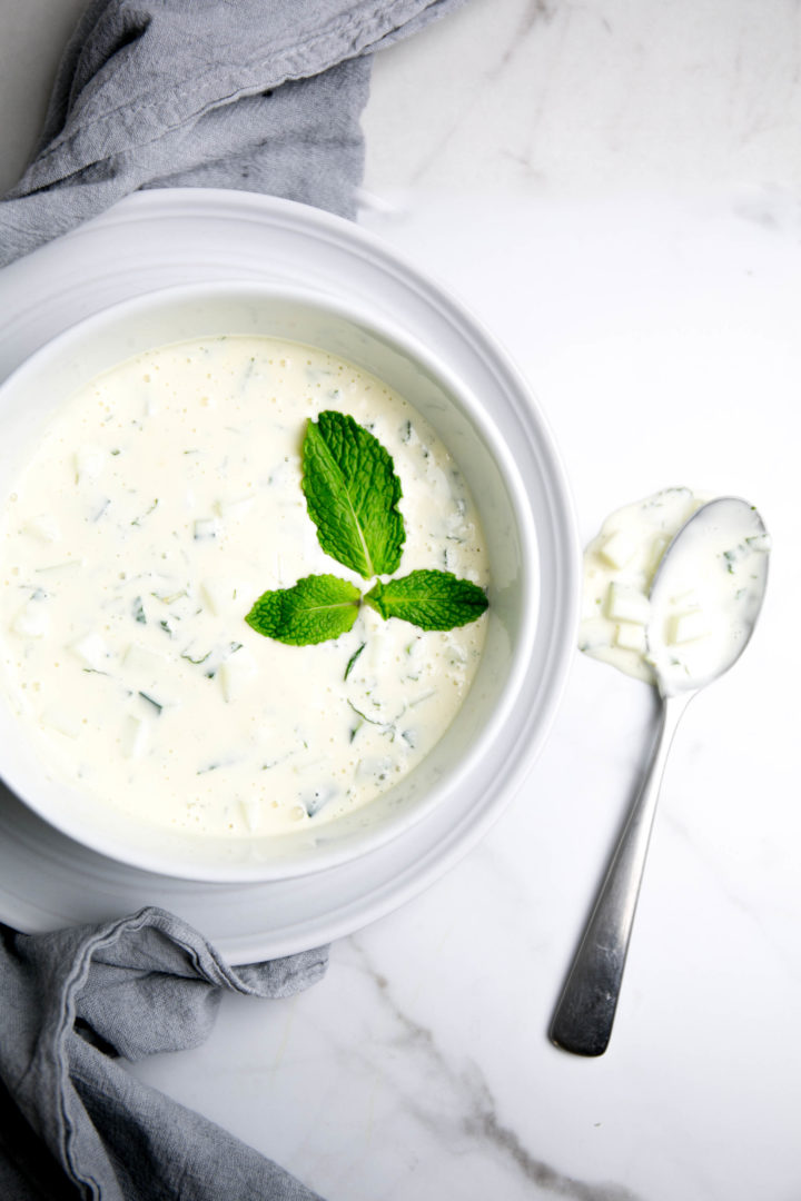 Tzatziki sauce in a bowl with a spoon and mint