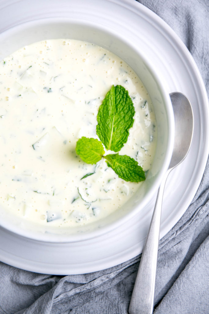 Up close view of tzatziki sauce with fresh mint and spoon