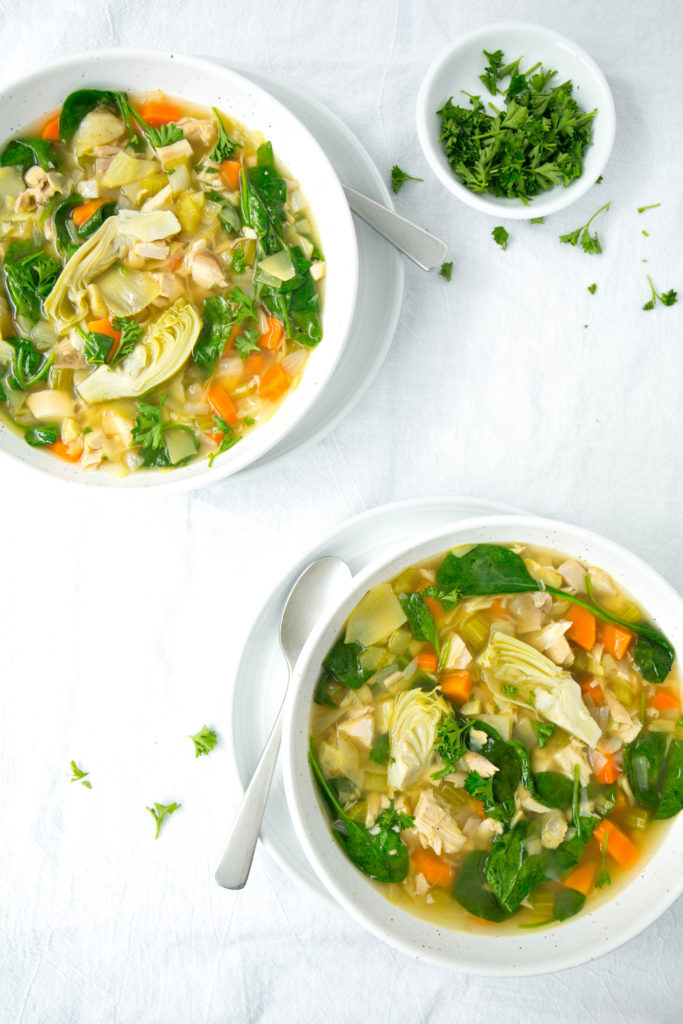 Two bowls of artichoke soup with parsley