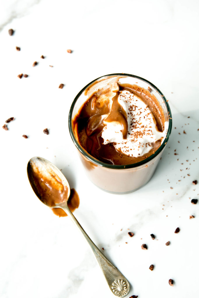 Chocolate pudding in a glass dish with a spoon