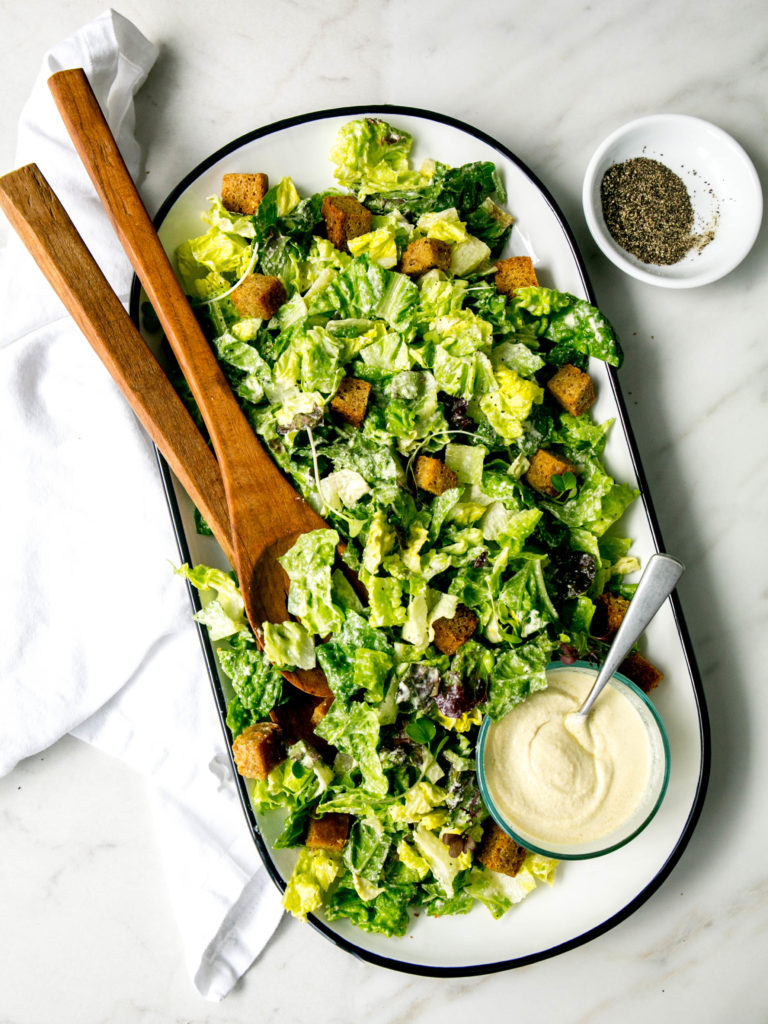Caesar salad dressing on a plate with lettuce and croutons