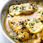 Chicken piccata in a pan with lemon and parsley