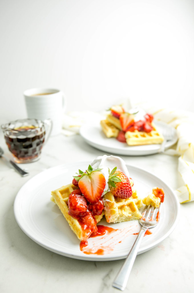 Waffles with strawberry sauce, maple syrup and coffee