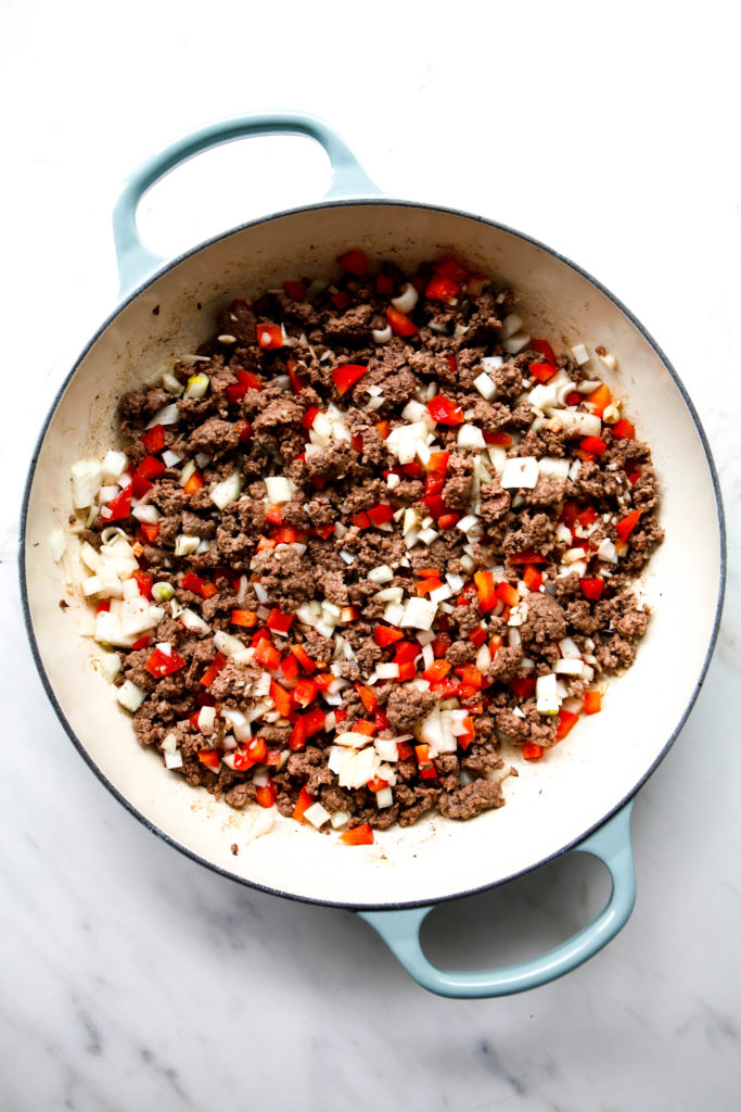 beef picadillo with onions and red bell peppers in sauce pan