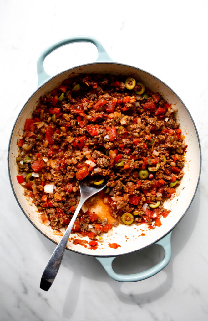 beef picadillo in sauce pan with serving spoon