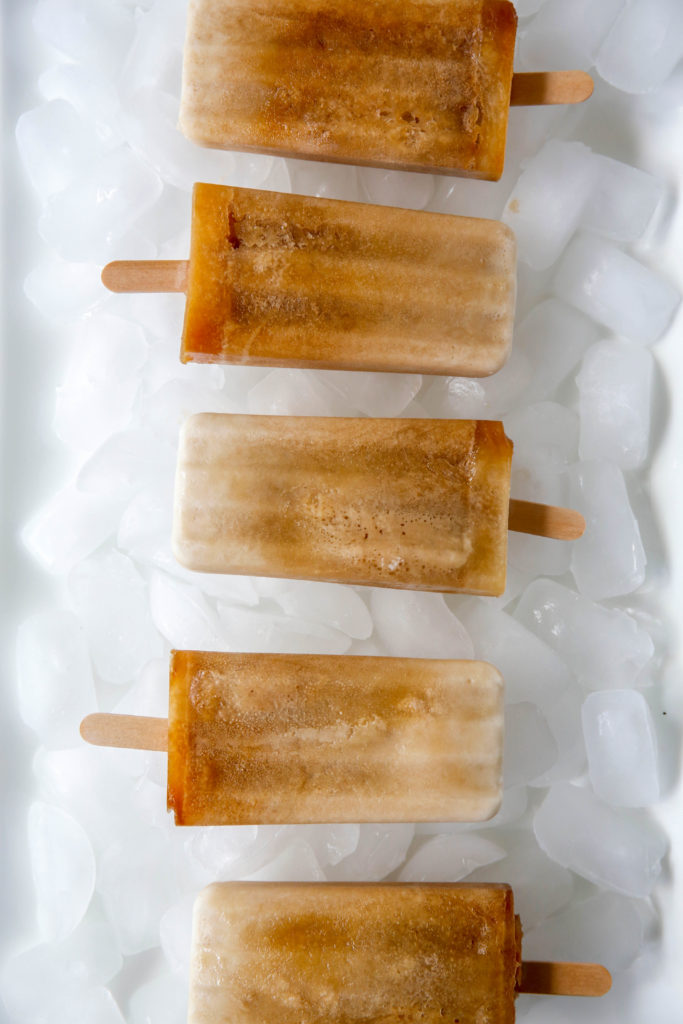 five root beer float popsicles in a row over ice