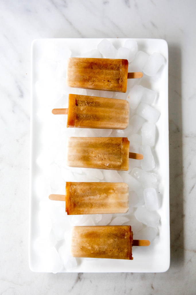 root beer float popsicles in a row over a bed of ice cubes