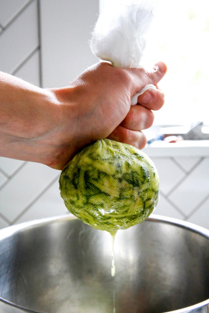 zucchini being squeezed out of cheese cloth