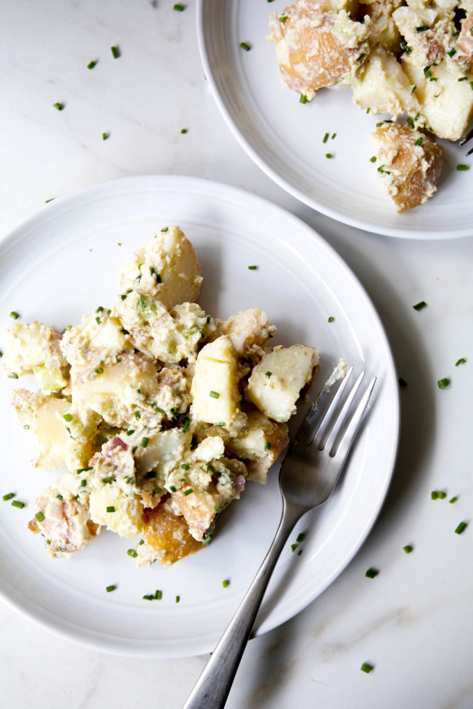 caesar potato salad on a plate with a fork