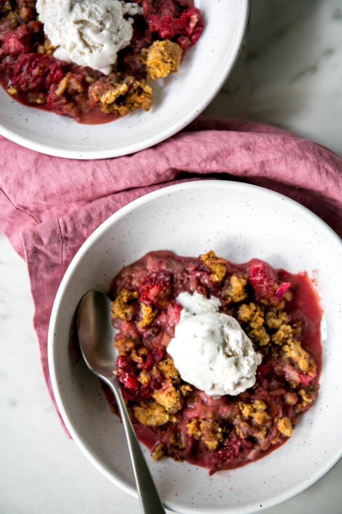 two bowls of strawberry rhubarb crisp with ice cream
