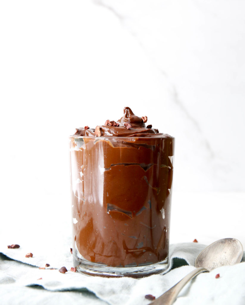 chocolate avocado mousse in a glass jar with a spoon and napkin
