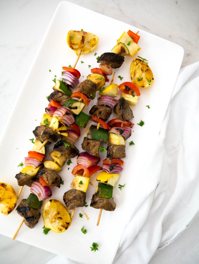 Beef Skewers with peppers and onions on a platter