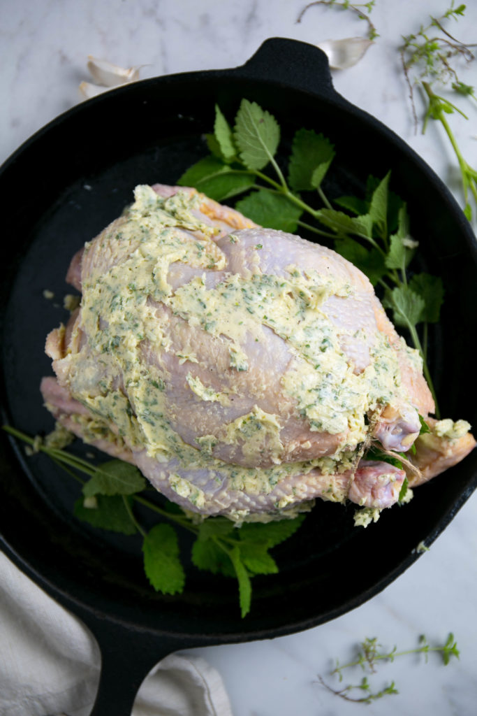 Lemon balm roast chicken covered in butter before being roasted