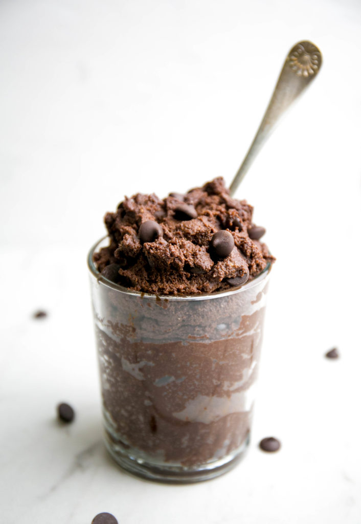 raw brownie batter in a glass container with spoon