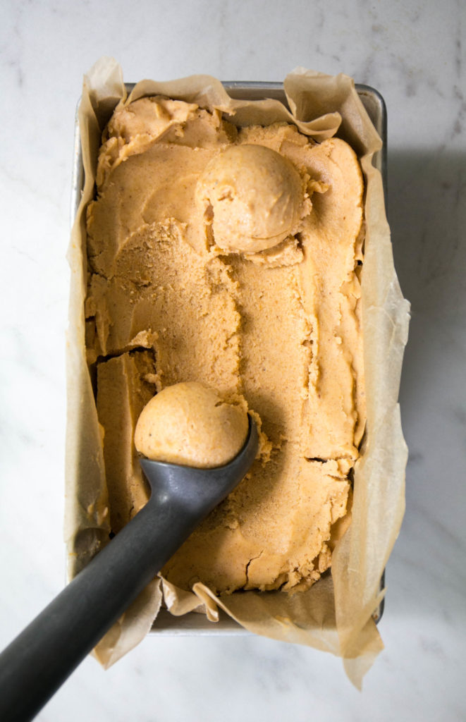 Frozen pumpkin ice cream with an ice cream scoop