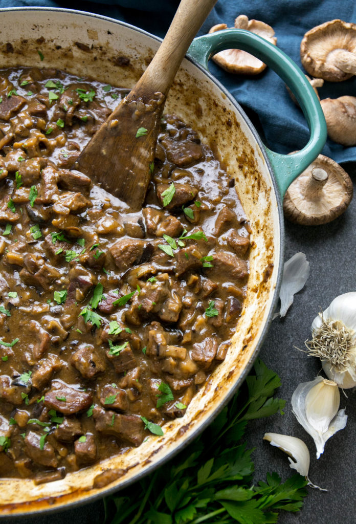 A large skillet of beef stroganoff with parsley, garlic and mushrooms