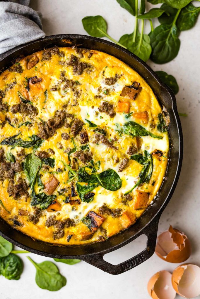 Aerial view of breakfast casserole in a cast iron with sausage and spinach