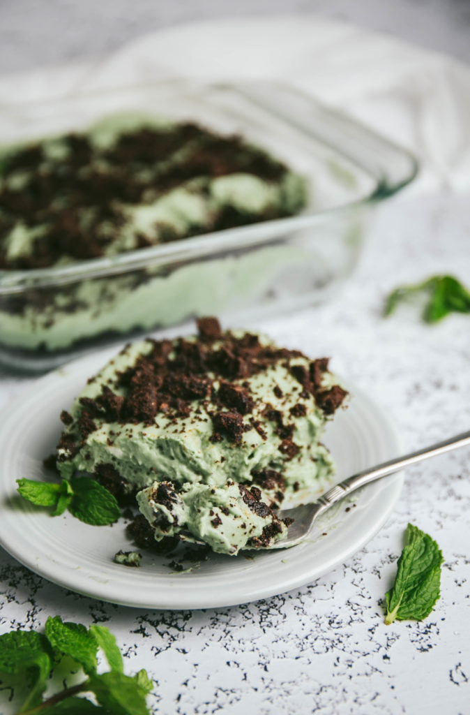Grasshopper pie on a plate with a fork full of pie and mint leaves