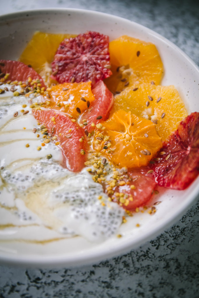 healthy citrus breakfast bowl with yogurt, honey, and bee pollen