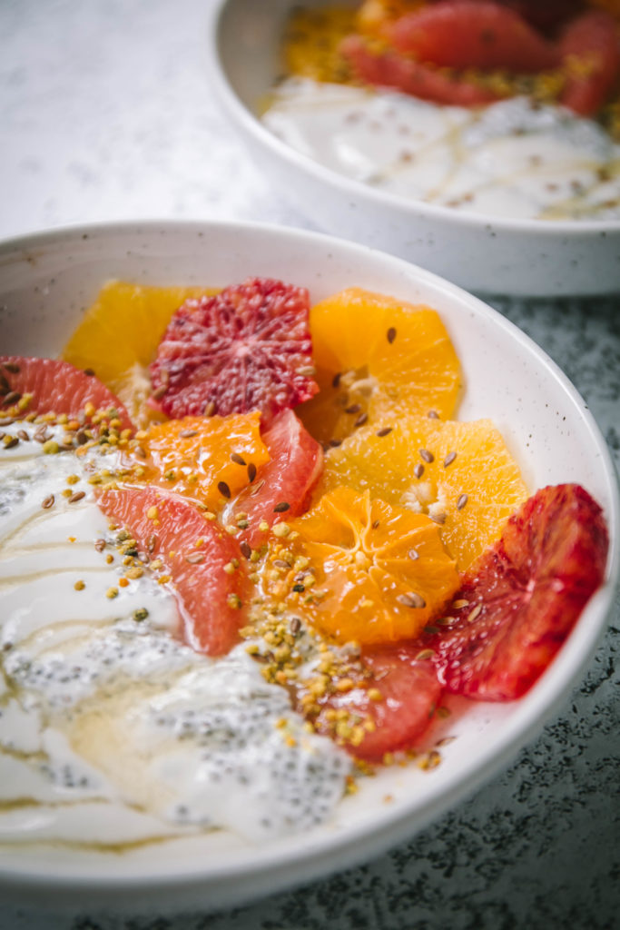 up close picture of citrus fruit in a bowl with yogurt and honey