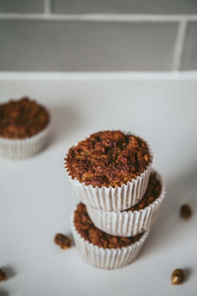 White mulberry muffins stacked on top of each other with dried mulberries sprinkled around