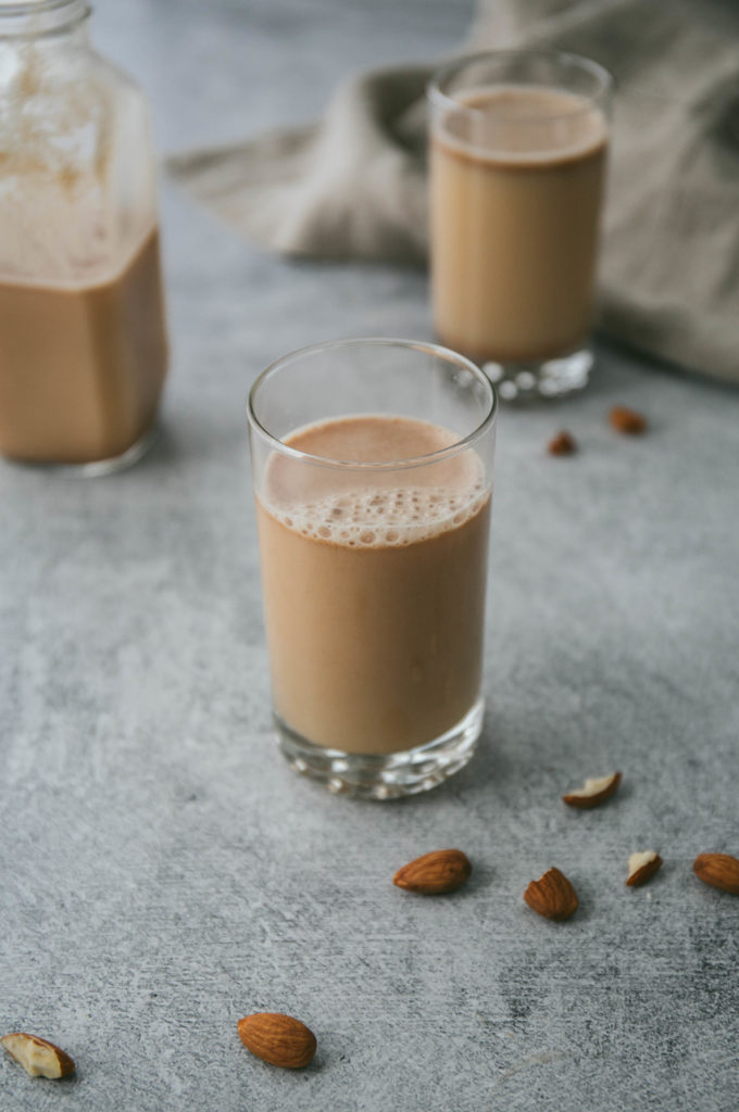 2-minute almond milk in a glass with crushed almonds around it