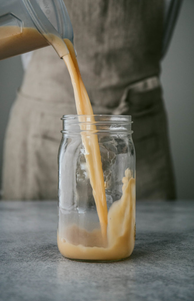 2-minute almond milk being poured into a mason jar