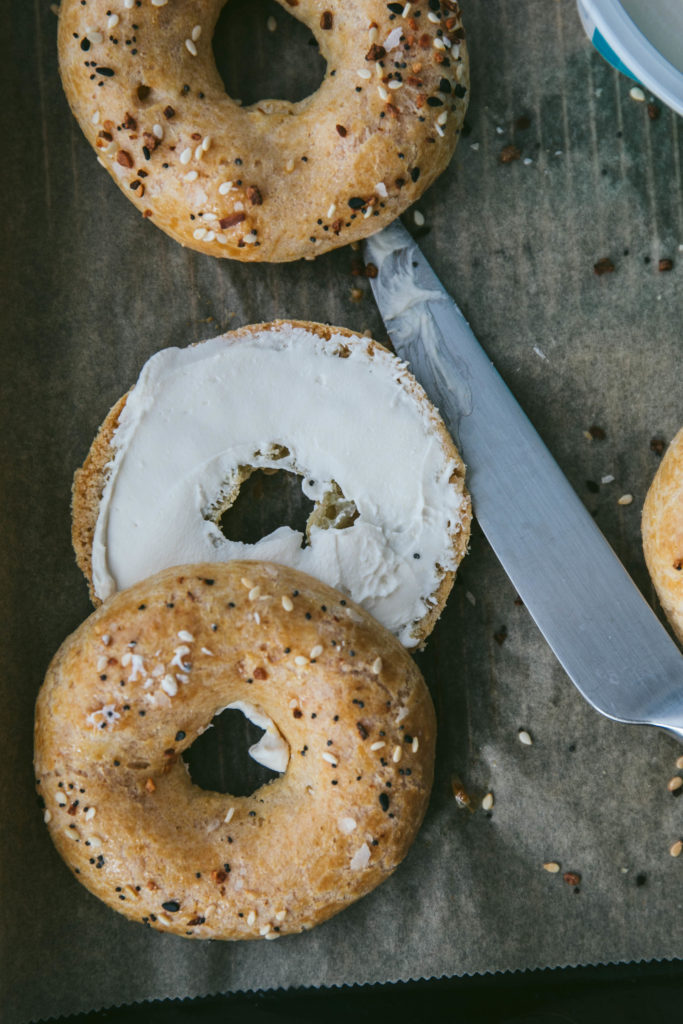 Grain-free everything bagel sliced in half with dairy-free cream cheese