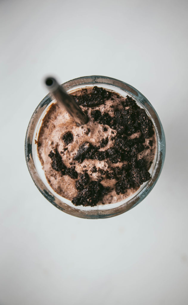 Aerial view of milkshake with cookies and a straw