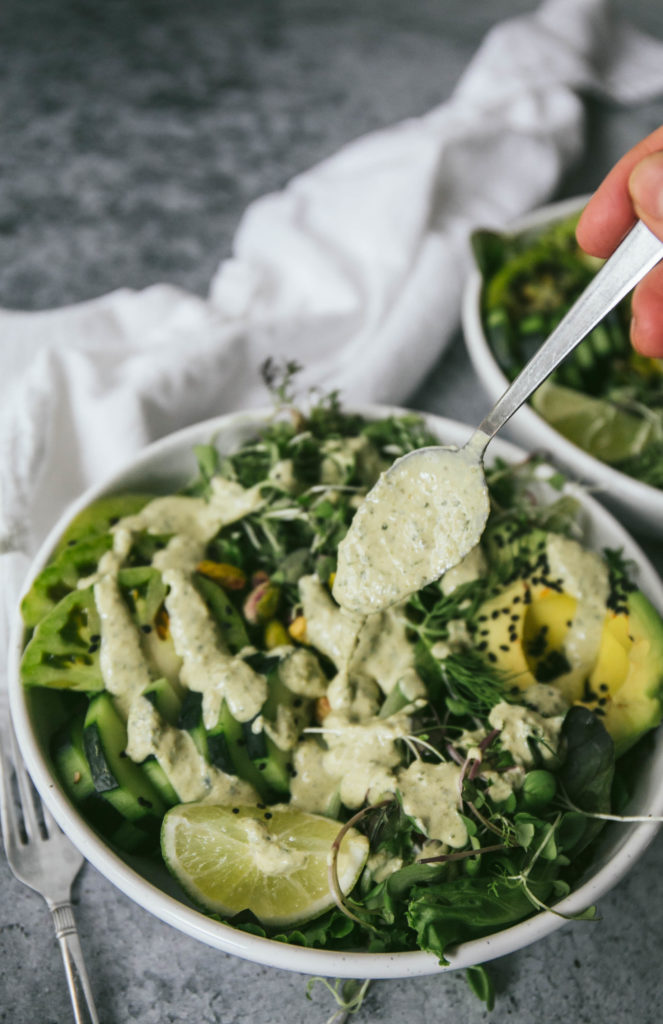 green goddess dressing being drizzled on a salad