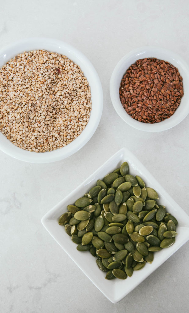 Sesame seeds, pumpkin seeds and flaxseeds in little bowls