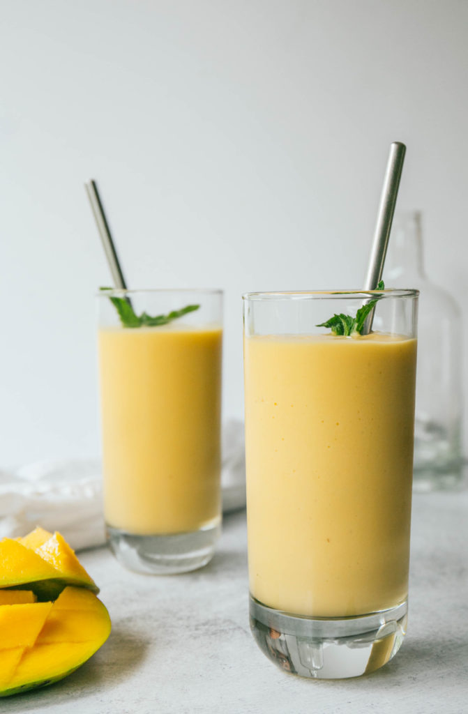 Two mango lassi smoothies with mango