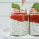 Strawberry rhubarb chia seed pudding in two glass jars with spoon