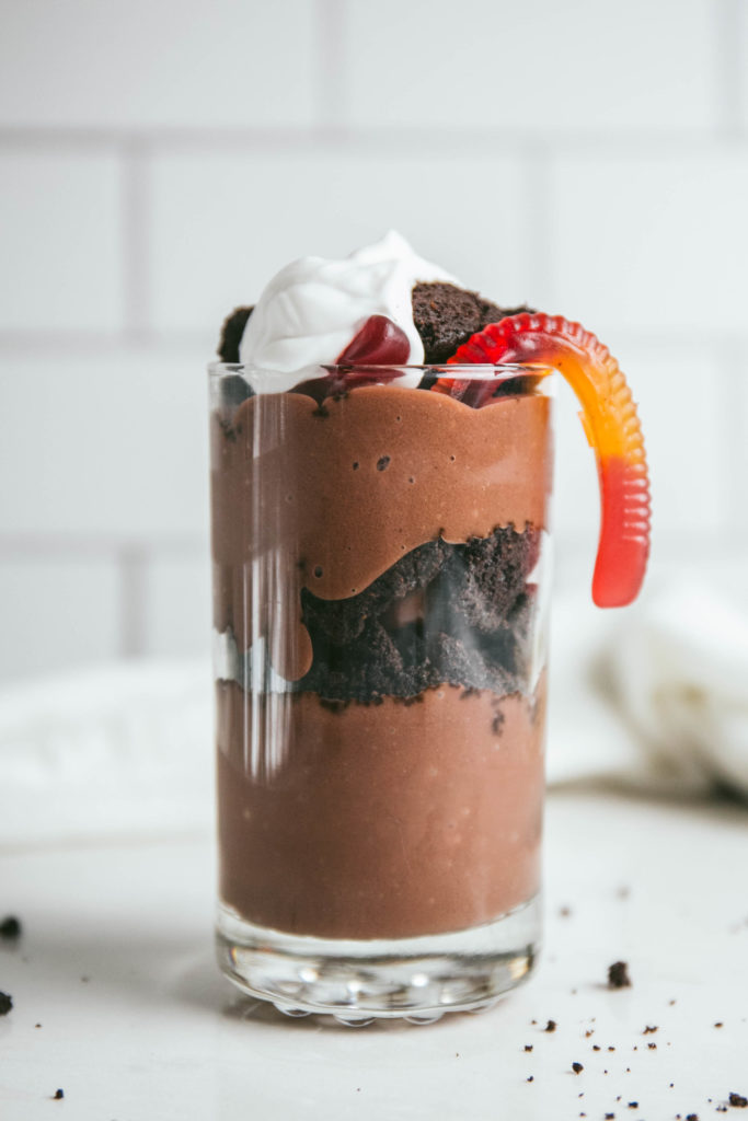 Dirt cup in a glass with whipped cream and gummy worm