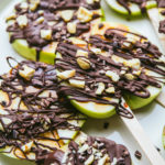 Caramel apple lollipops with chocolate and chopped cashews
