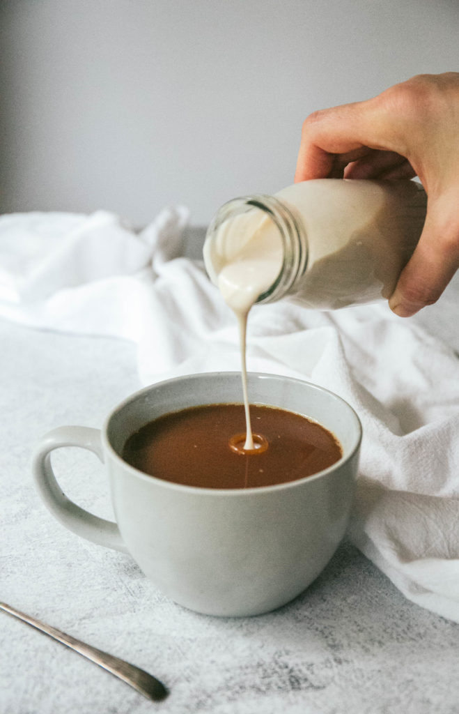 Vanilla coffee creamer being poured into a cup of coffee