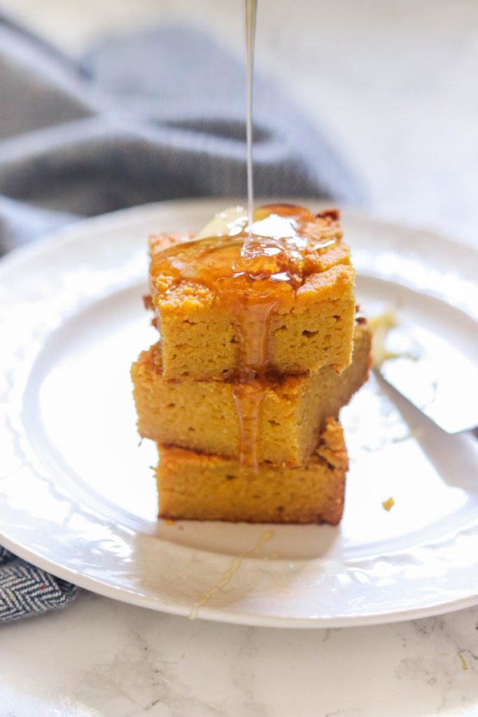Paleo cornbread on a plate with honey drizzled on top