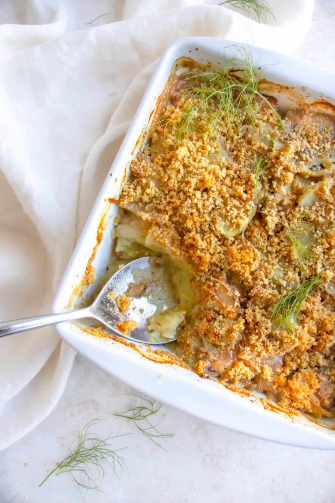 Fennel and sweet potato casserole with a serving spoon