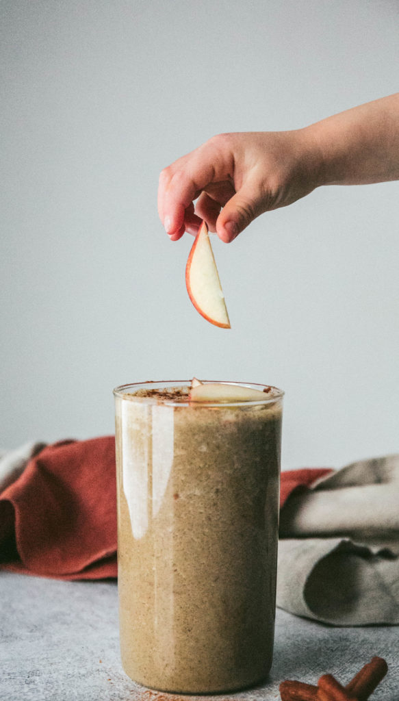 An apple falling into a warm apple pie smoothie