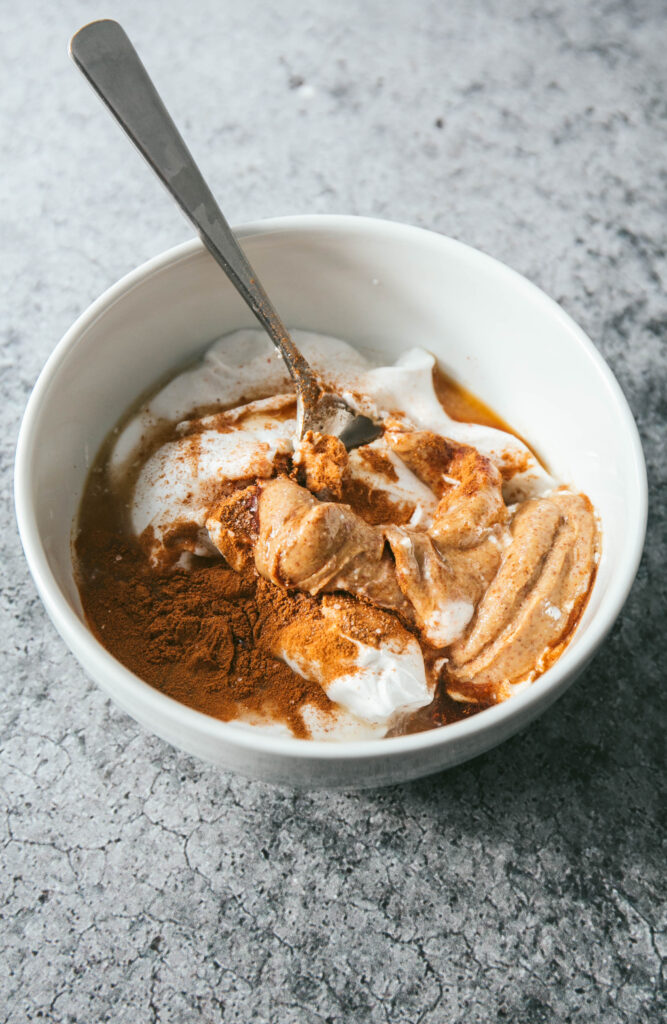 coconut almond whip ingredients in a bowl with a spoon