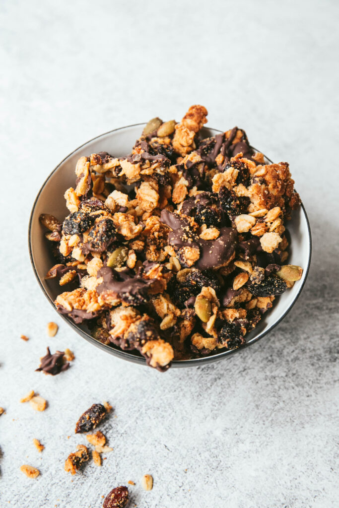 Upclose view of trail mix granola in a bowl with some on the table