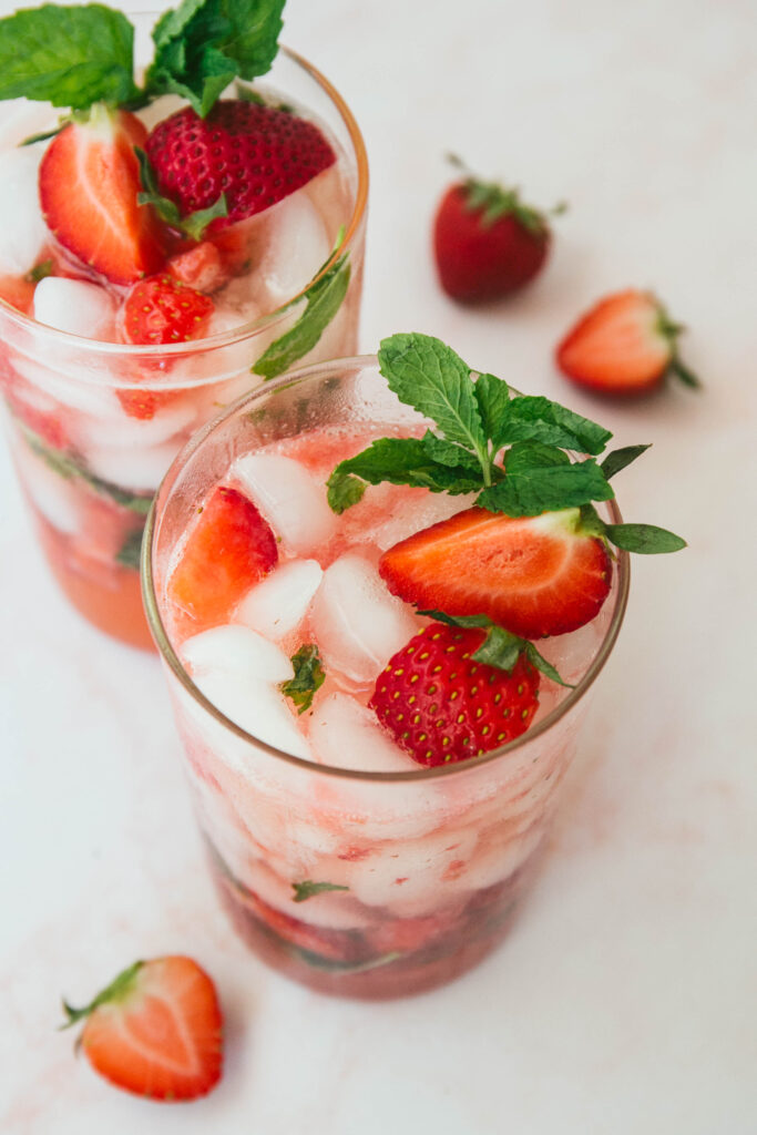 Two strawberry mint mocktails with fresh mint and strawberries