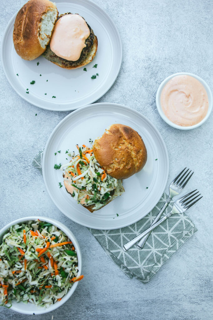 Aerial view of Thai turkey burgers with spicy mayo and coleslaw