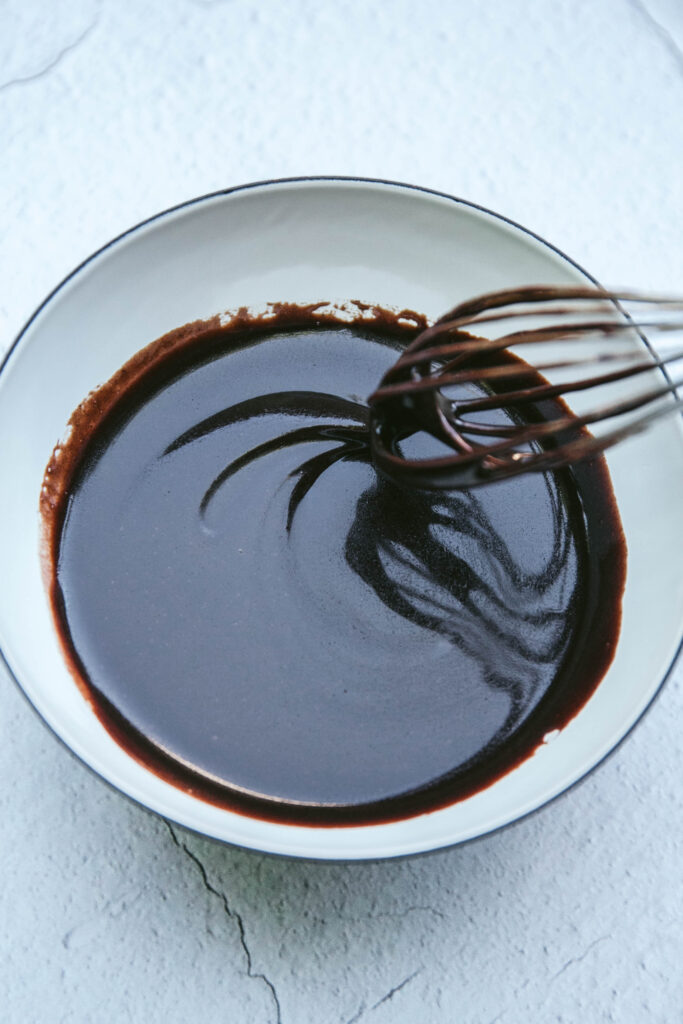 Chocolate sauce being mixed with a whisk